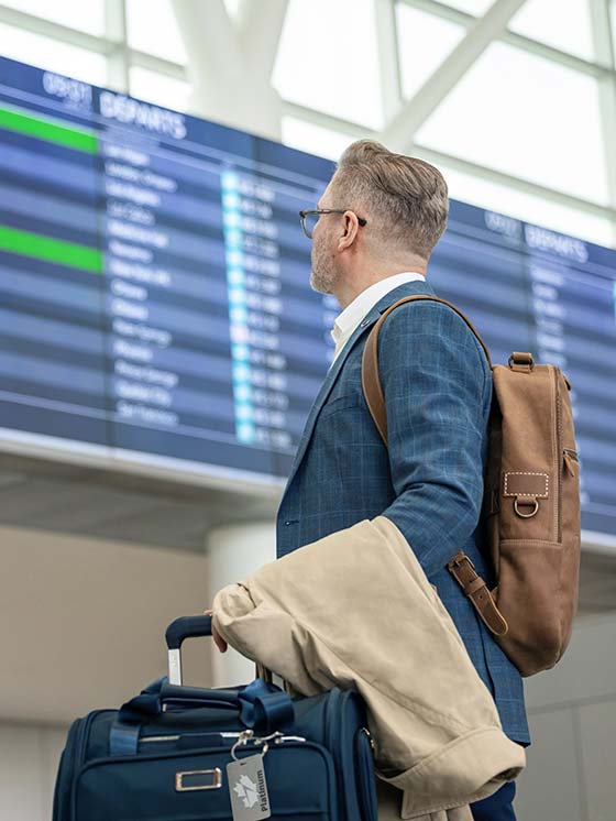 Business man looks at flight list in the boarding lounge