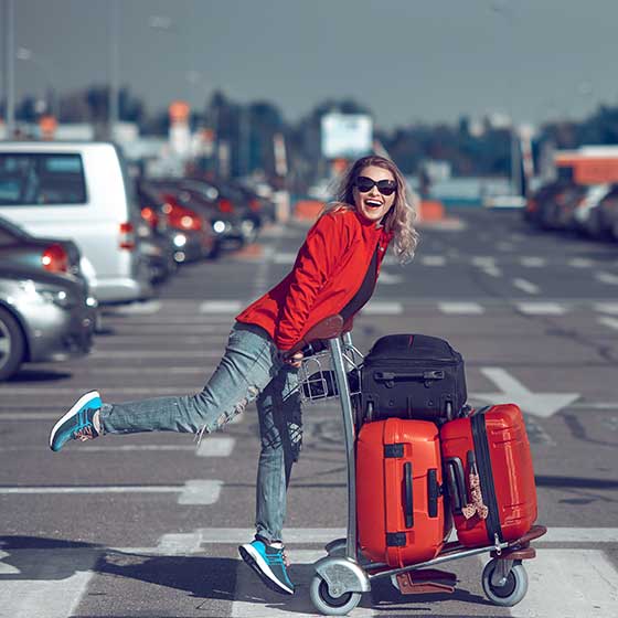 Woman pushing luggage in airport parking