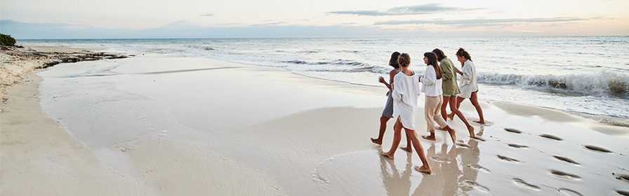 Friends walking along a beach in Mexico